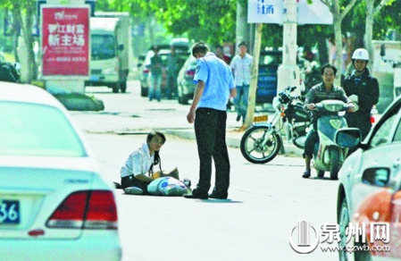 女孩從摩的上摔下，跌坐路中央，恰遇社區(qū)聯(lián)防巡邏人員扶起。