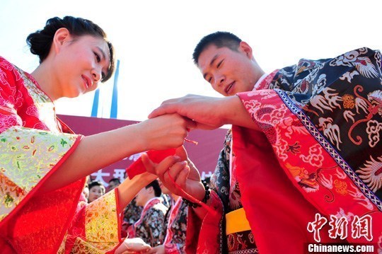 9月1日，一場別開生面的“重溫漢唐風”漢式集體婚禮在泉城濟南舉行，72名新人身著傳統(tǒng)漢服喜結良緣，并在許愿墻上許下“千年共枕眠，一世永相愛”心愿。圖為新人解纓結發(fā)。中新社發(fā) 張勇 攝