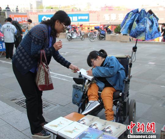 洛洛正在給買書的顧客簽名。 馮曉林 攝